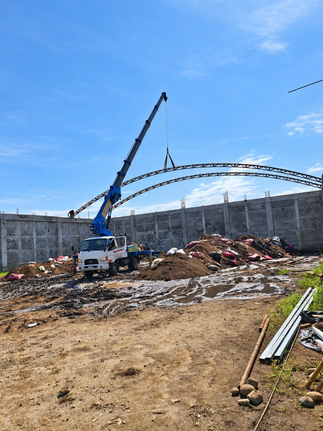 Grúa izando componentes de una estructura metálica en obra