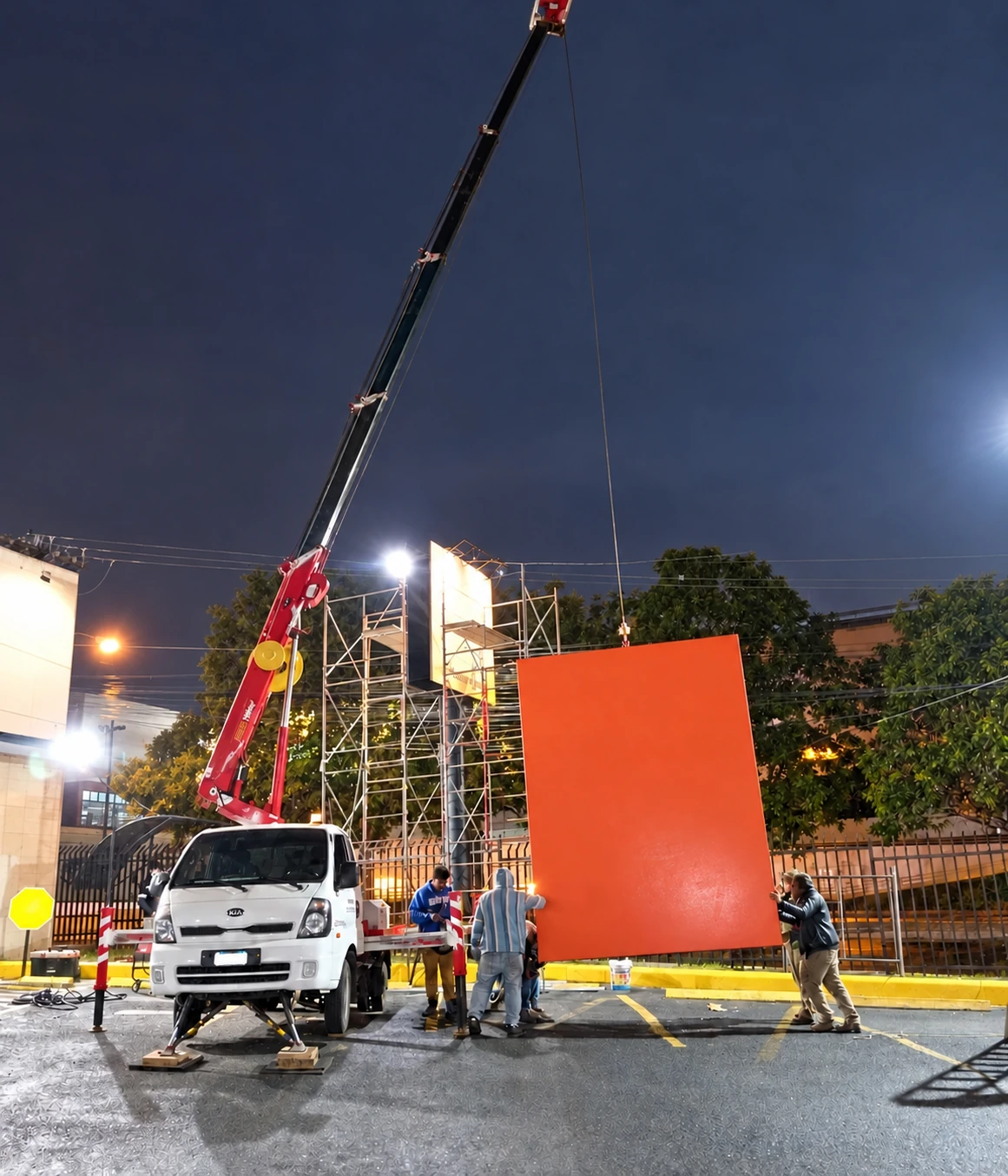 Grúas en la instalación nocturna de un elemento comercial